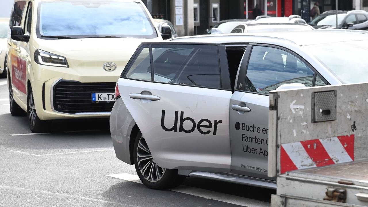 Ein Uber-Fahrzeug parkt vor einem Taxi mit Kölner Kennzeichen.