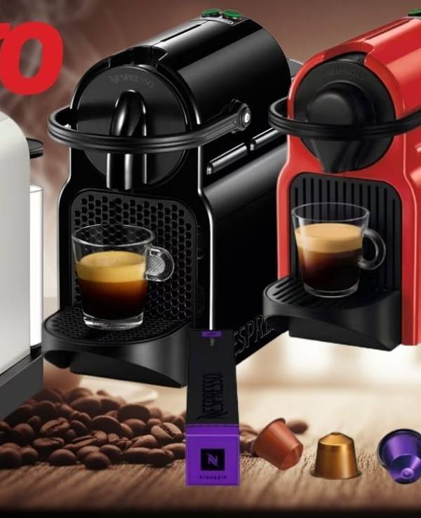 Mehrere Nespresso-Kaffeemaschinen in verschiedenen Farben (weiß, schwarz, rot) und Modellen (Inissia, Vertuo Next) sind auf einer Holzoberfläche mit verstreuten Kaffeebohnen und Nespresso-Kapseln zu sehen. Vor den Maschinen stehen Tassen mit frisch gebrühtem Kaffee. Oben links ist das OTTO-Logo platziert
