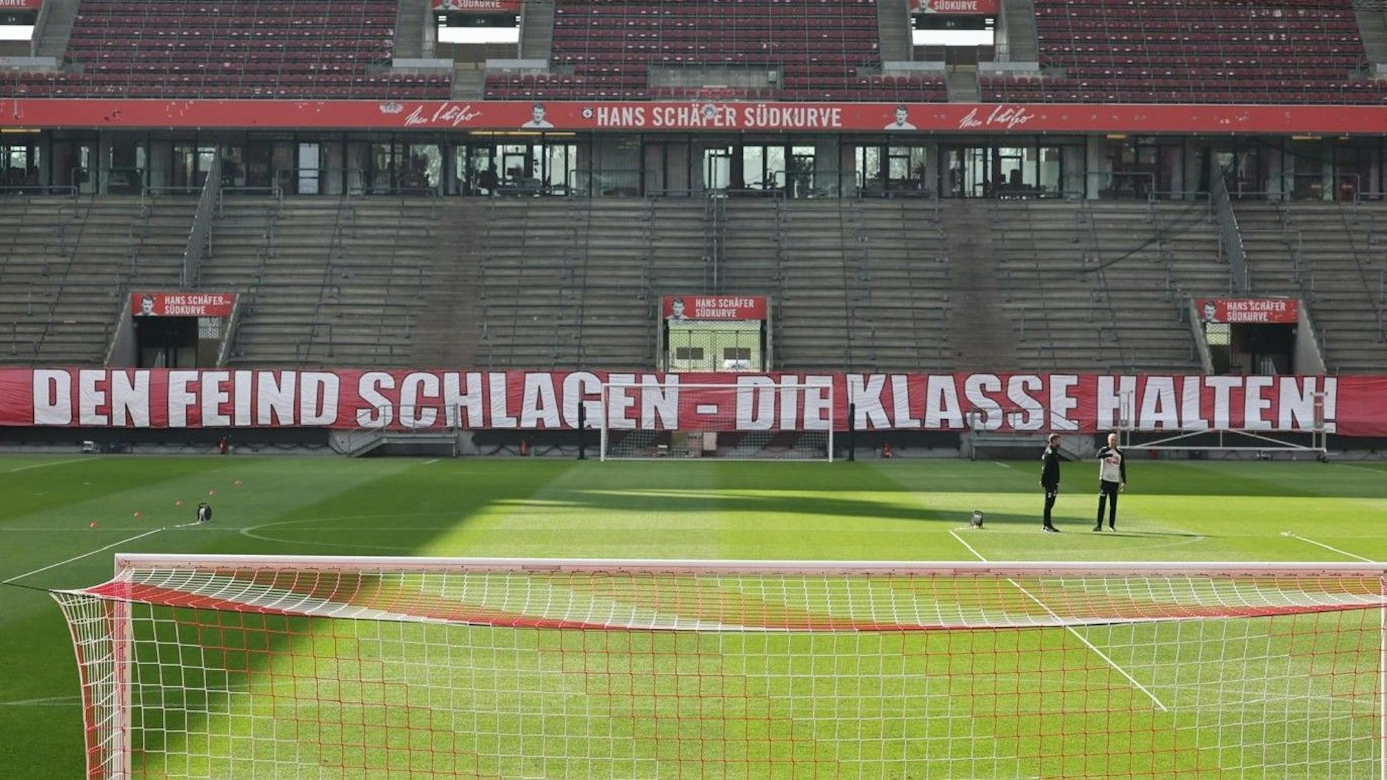 „Den Feind schlagen – die Klasse halten“, steht auf einem Banner, das FC-Fans im Stadion aufgehängt haben.