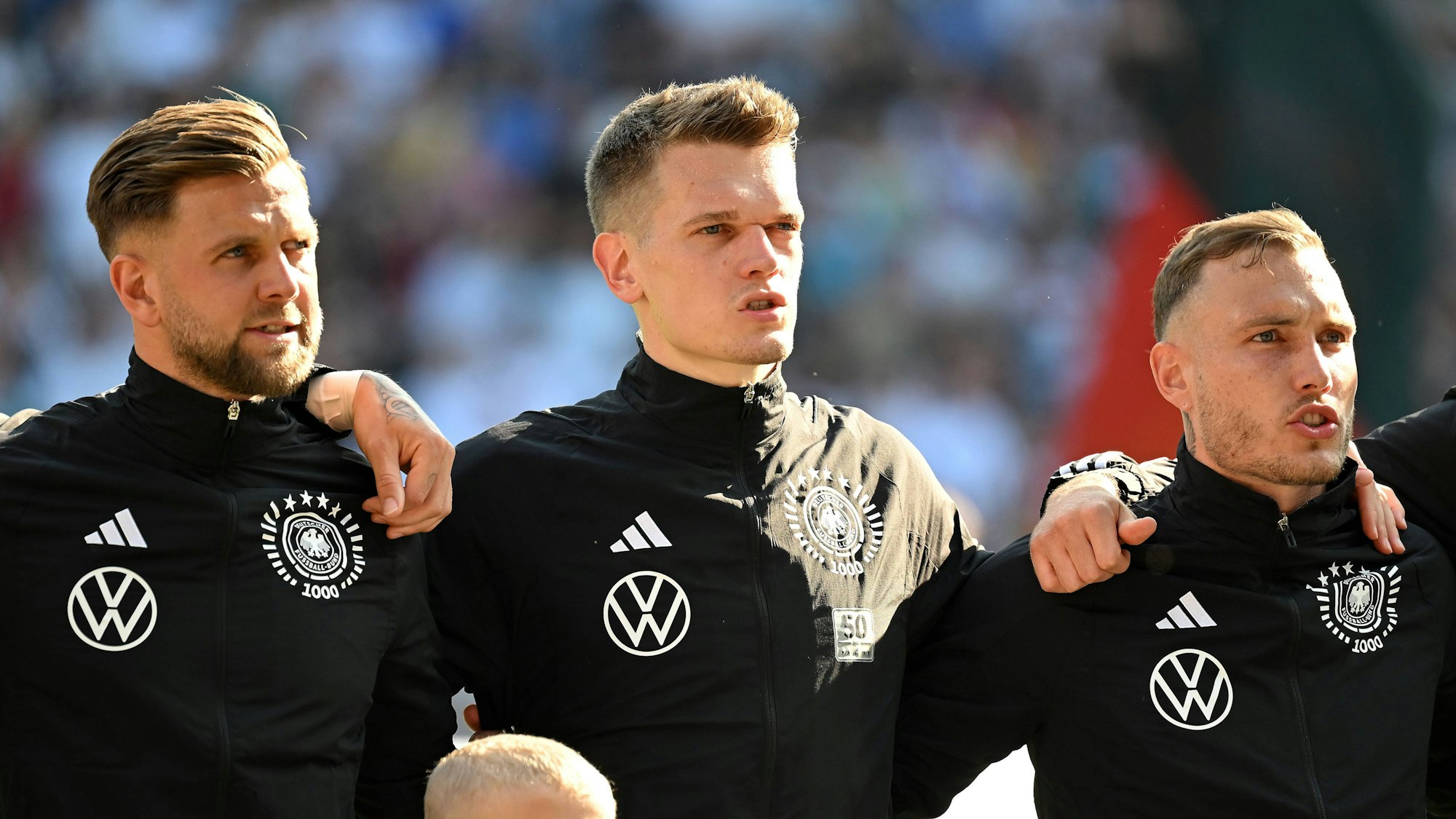 Matthias Ginter steht bei der Hymne zwischen Niclas Füllkrug und David Raum.