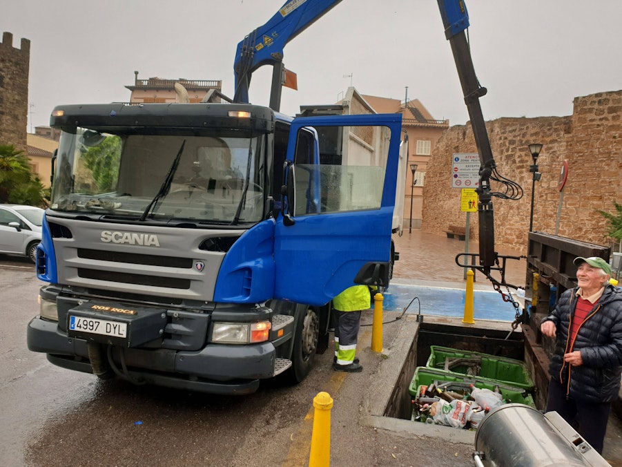 LKW mit Kran und Personen leeren Abfallcontainer