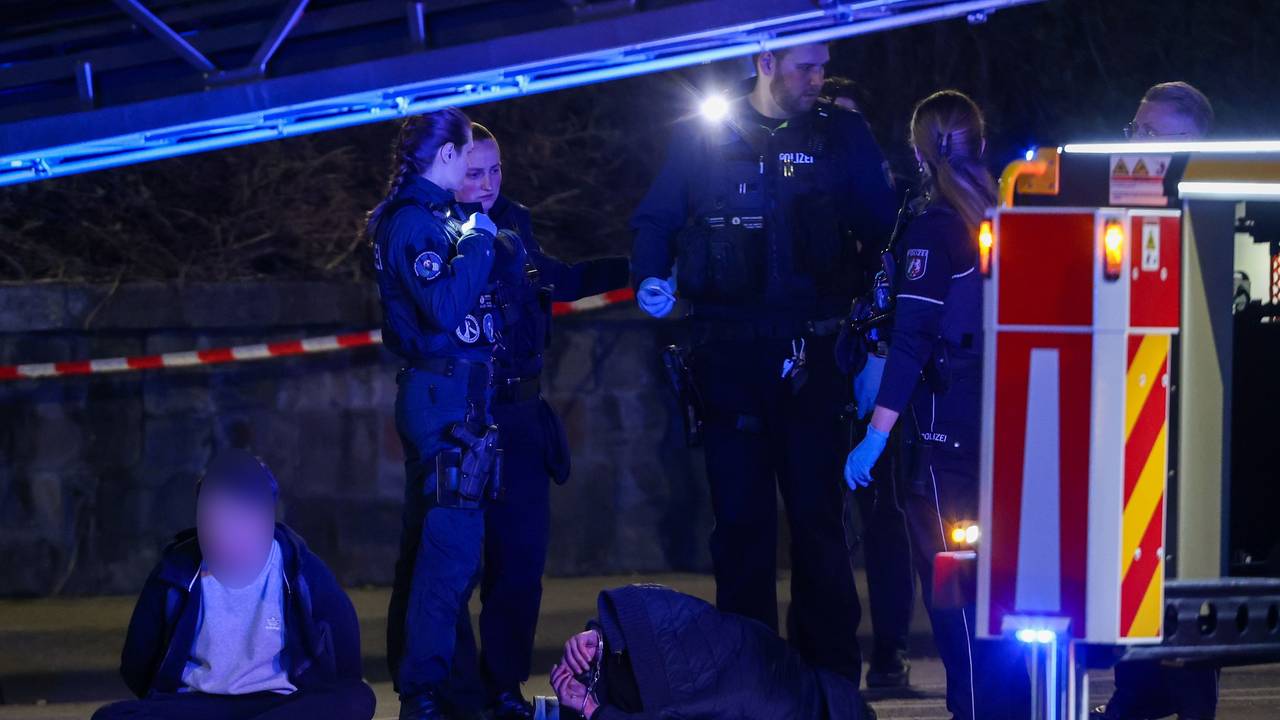 19.03.2026, Nordrhein-Westfalen, Mönchengladbach: Zwei Tatverdächtige sitzen und liegen in Handschellen gefesselt auf einer Straße, bewacht von Polizeibeamten. In der Innenstadt waren zuvor Schüsse gefallen. Es gebe Verletzte, sagte ein Polizeisprecher. Foto: Christoph Reichwein/dpa - ACHTUNG: Tatverdächtige Person wurde aus rechtlichen Gründen gepixelt +++ dpa-Bildfunk +++