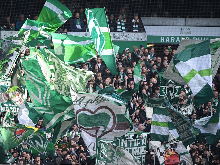 Ultras von Werder Bremen mit Fahnen im Fanblock.