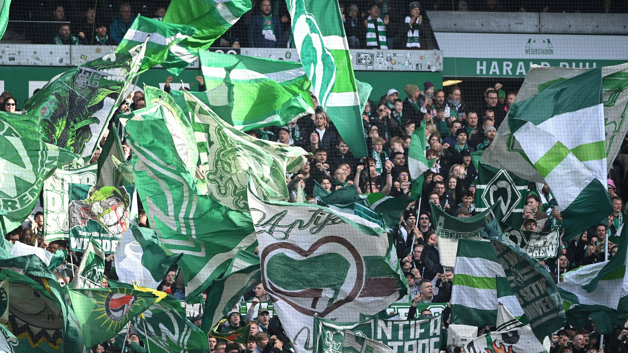 Ultras von Werder Bremen mit Fahnen im Fanblock.