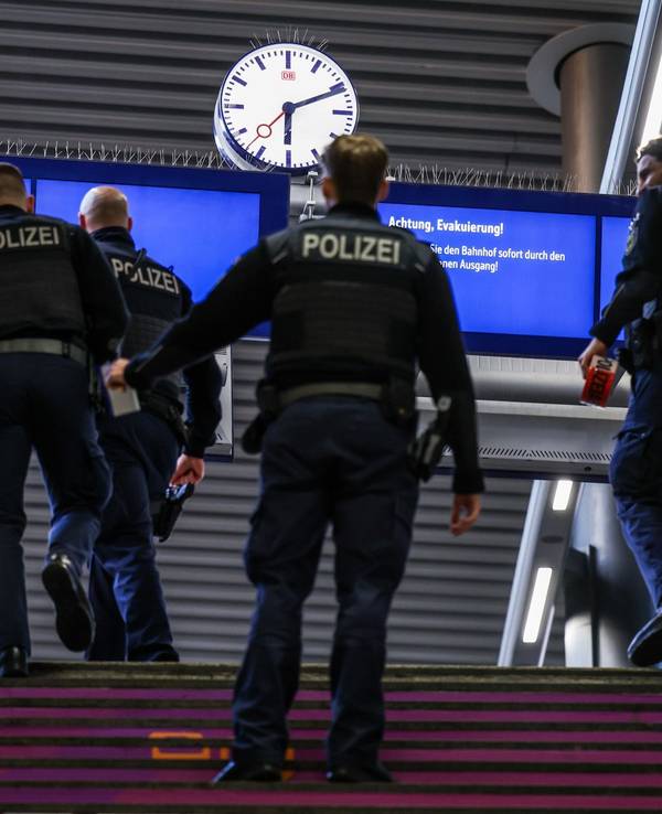 Beamte der Bundespolizei gehen zu einem Gleis.