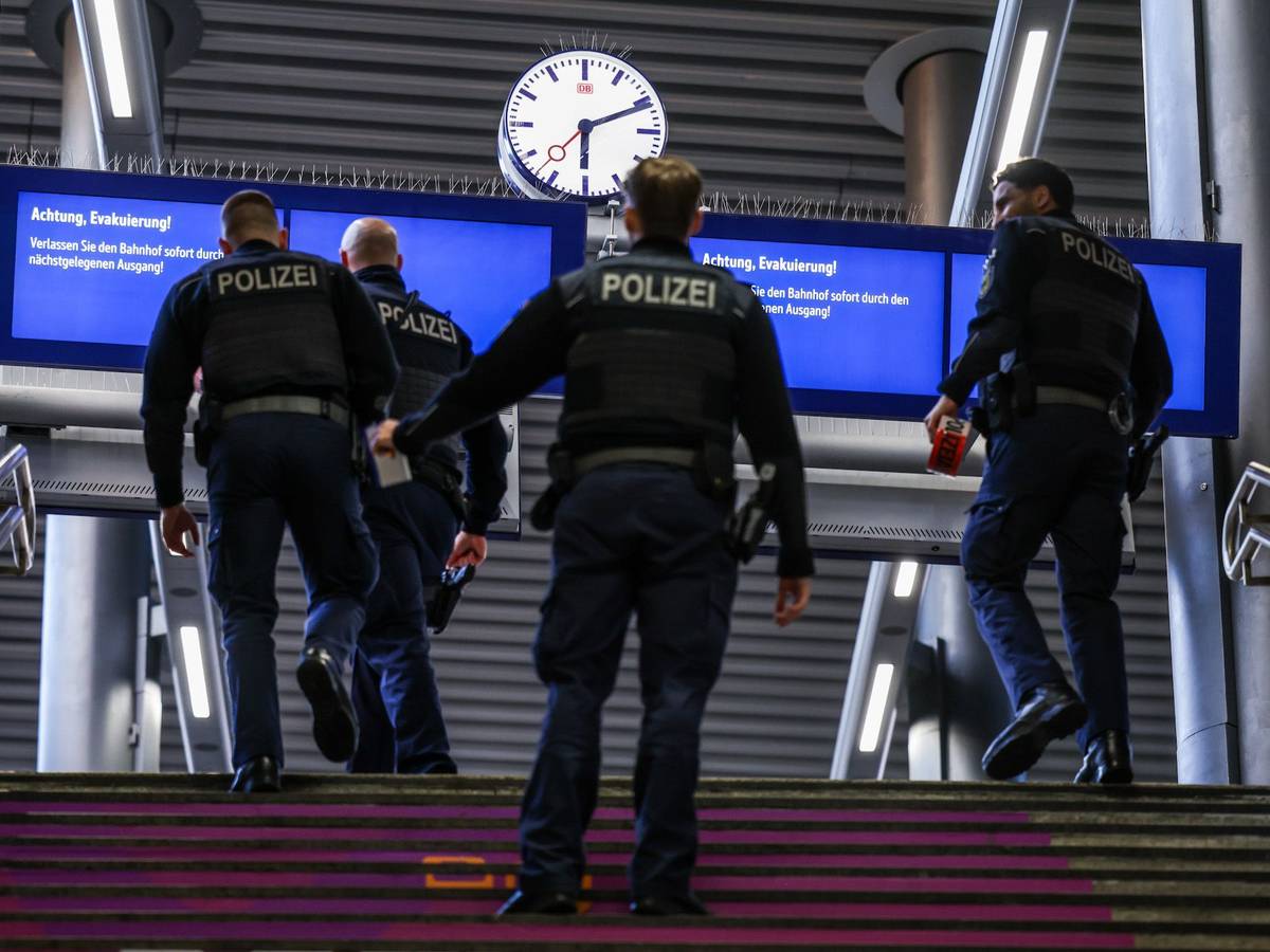 Beamte der Bundespolizei gehen zu einem Gleis.