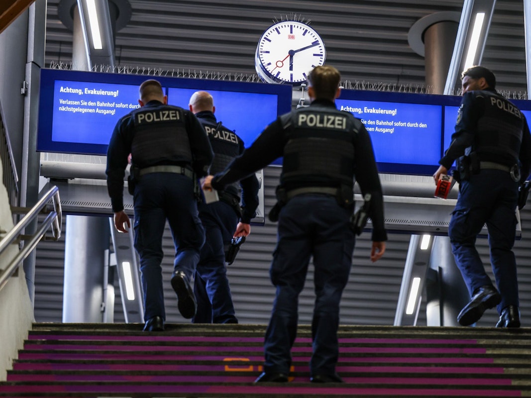 Beamte der Bundespolizei gehen zu einem Gleis.