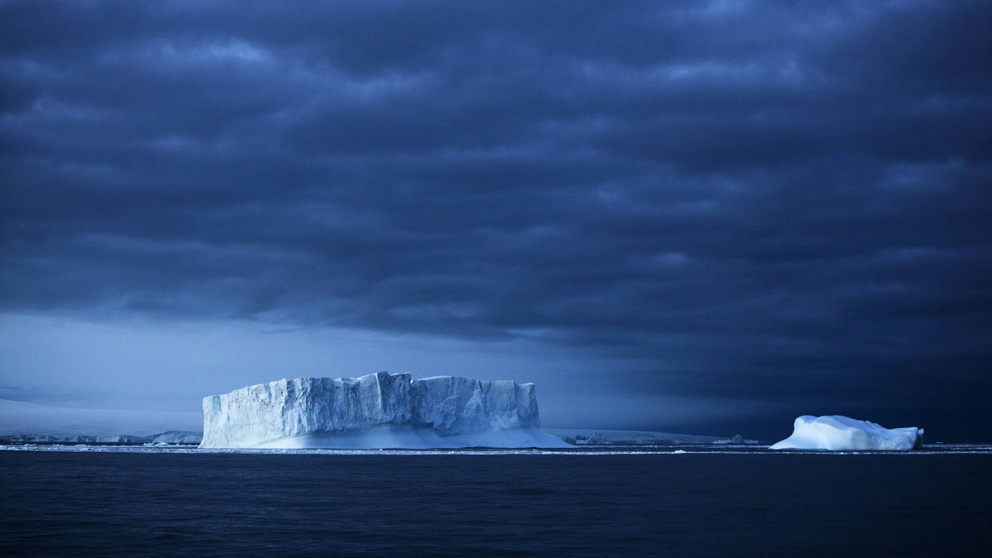Eisberge im Südpolarmeer unter dunklem Himmel