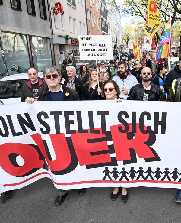 Menschen tragen ein Plakat mit der Aufschrift Köln stellt sich quer.