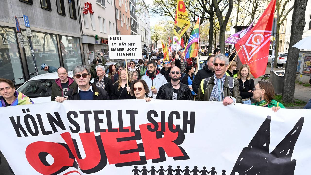 Menschen tragen ein Plakat mit der Aufschrift Köln stellt sich quer.