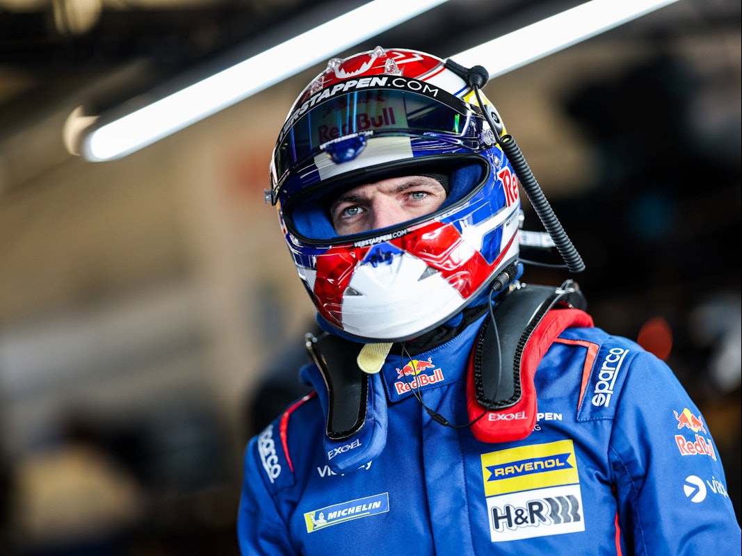 Max Verstappen in Rennanzug und Helm.