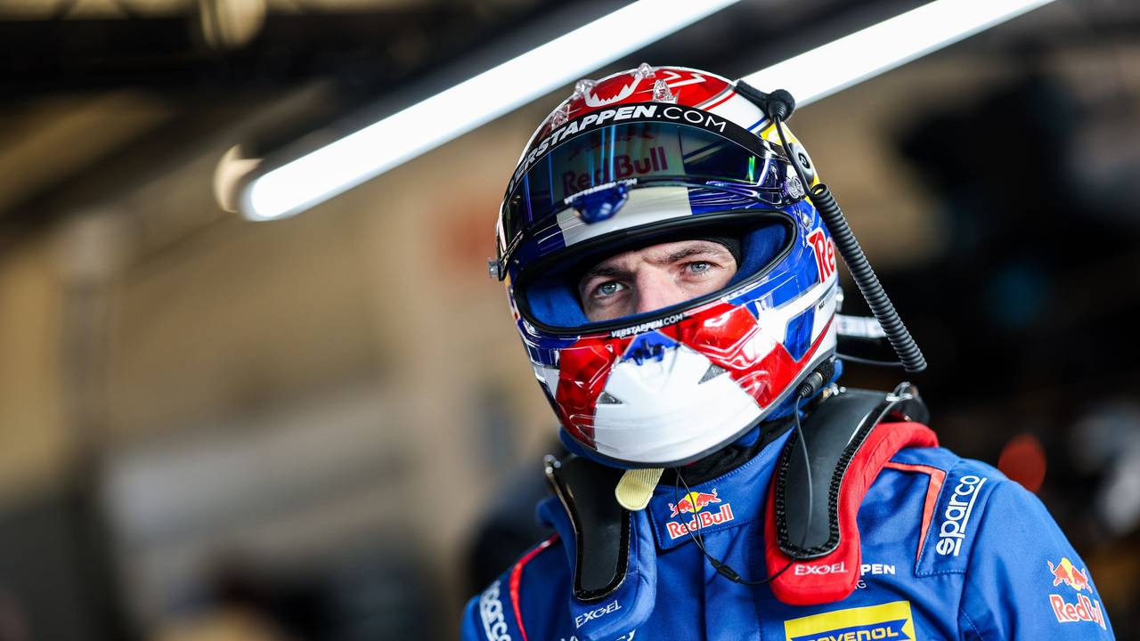 Max Verstappen in Rennanzug und Helm.