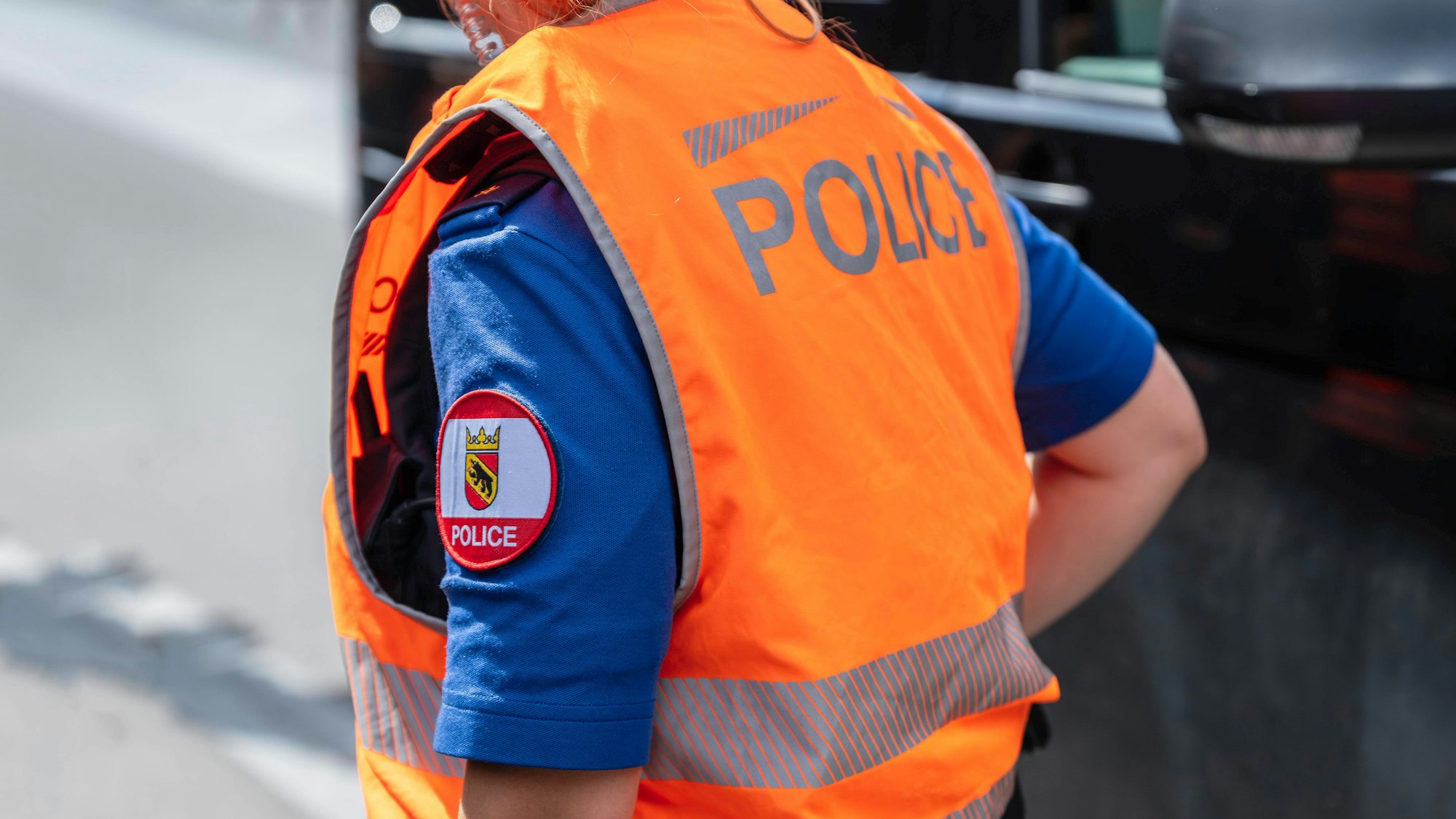 Polizistin in oranger Warnweste über blauer Uniform