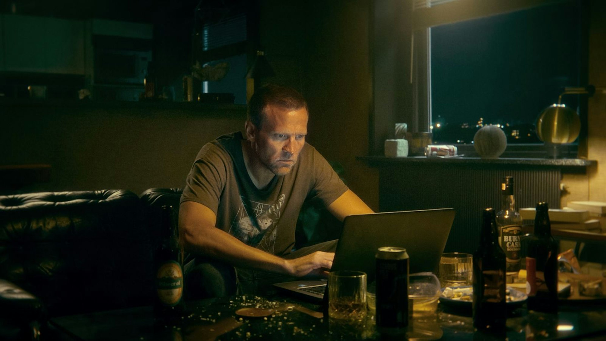 Nächtliche Online-Recherche von Harry Hole (Tobias Santelmann), der seine Freizeit in einer verranzten Hochhausbude mit Hochprozentigem und Punkrock verbringt. (Bild: Courtesy of Netflix © 2024)