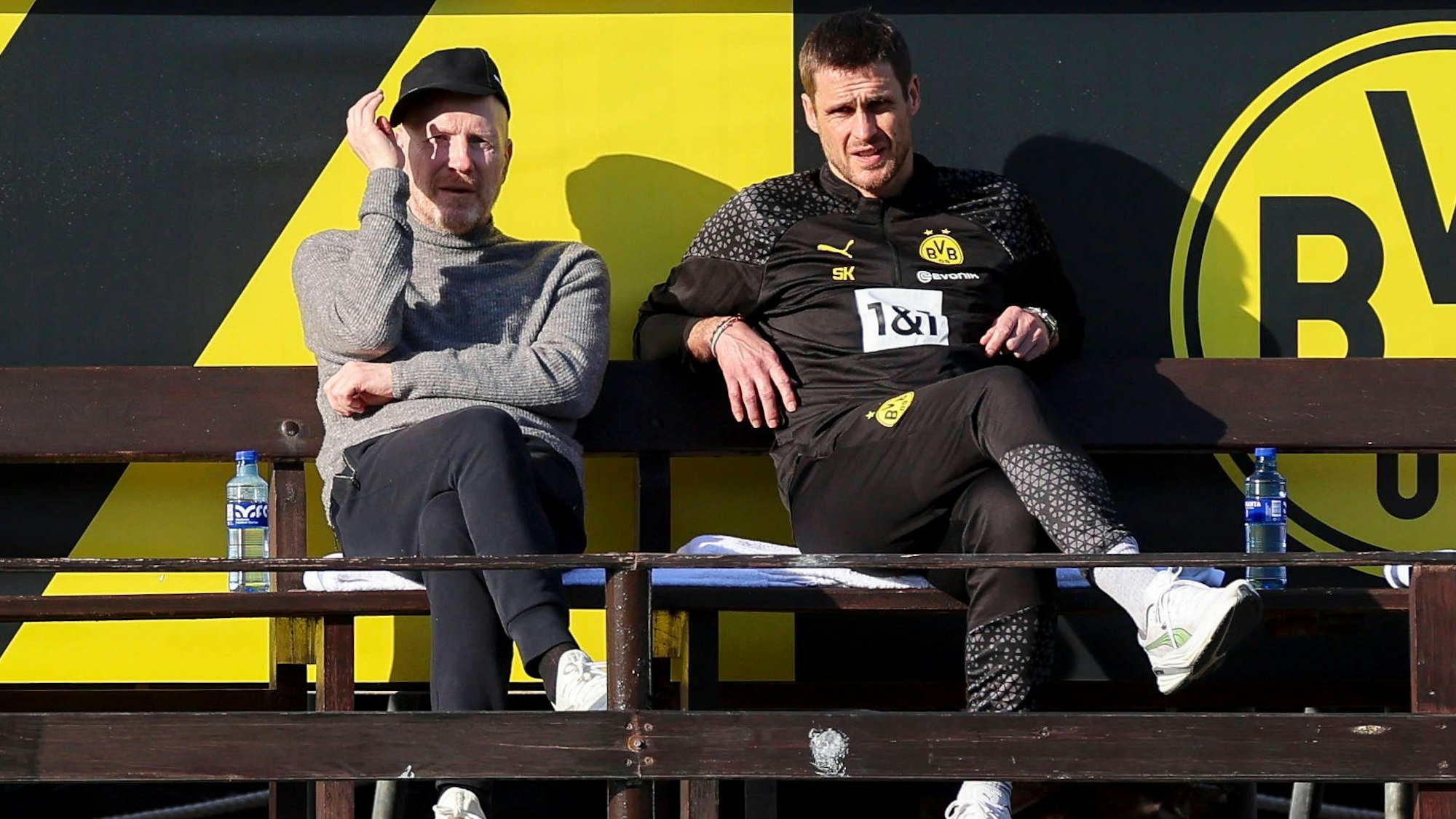 Matthias Sammer und Sebastian Kehl sitzen nebeneinander auf einer Bank.