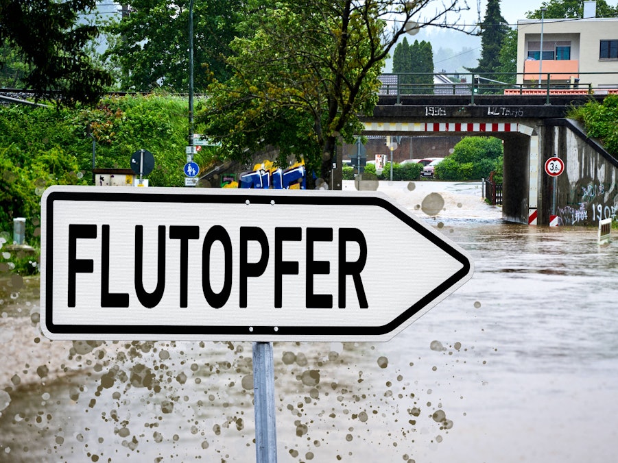 Flutopfer-Schild, Hochwasser, Überführung und Wohnhäuser