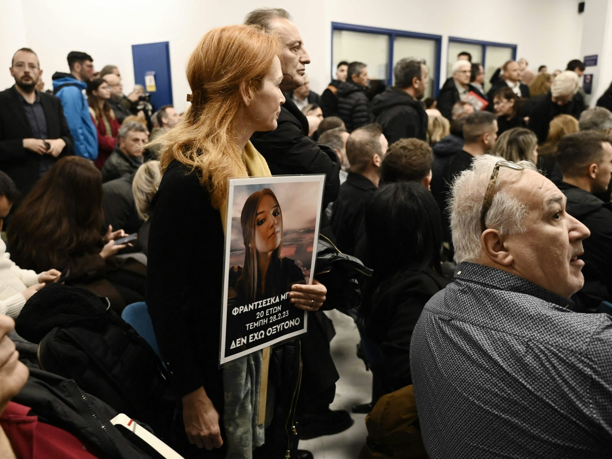 Angehörige zeigen das Bild eines Opfers, das beim schwersten Eisenbahnunglück in der Geschichte Griechenlands ums Leben kam. Im Gerichtssaal kochten die Emotionen über.