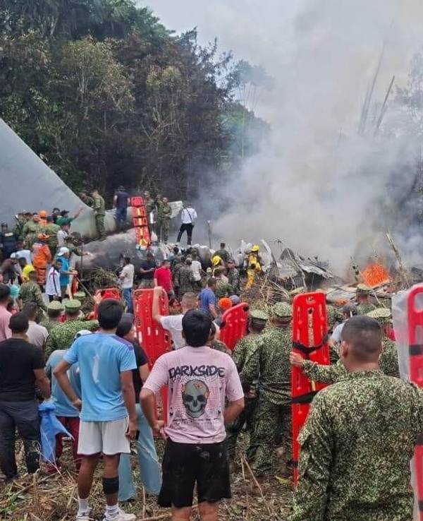Menschen stehen um ein militärisches Frachtflugzeug, das nach dem Start in Puerto Leguízamo, einer abgelegenen Gemeinde in der Amazonasprovinz Putumayo, abgestürzt ist.