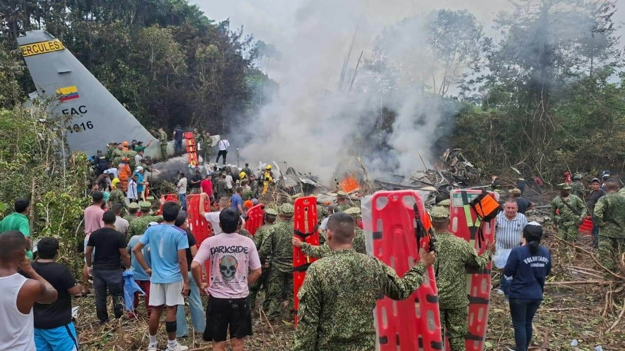 Menschen stehen um ein militärisches Frachtflugzeug, das nach dem Start in Puerto Leguízamo, einer abgelegenen Gemeinde in der Amazonasprovinz Putumayo, abgestürzt ist.