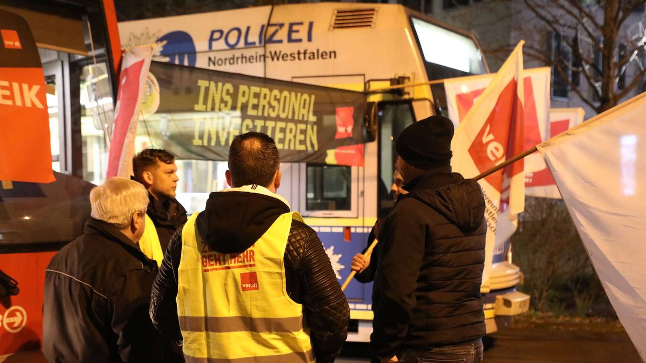 Streikende stehen mit Flaggen vor parkenden Stadtbahnen der KVB. In der Tarifrunde für den kommunalen Nahverkehr hatte Verdi für Montag zu Warnstreiks aufgerufen.