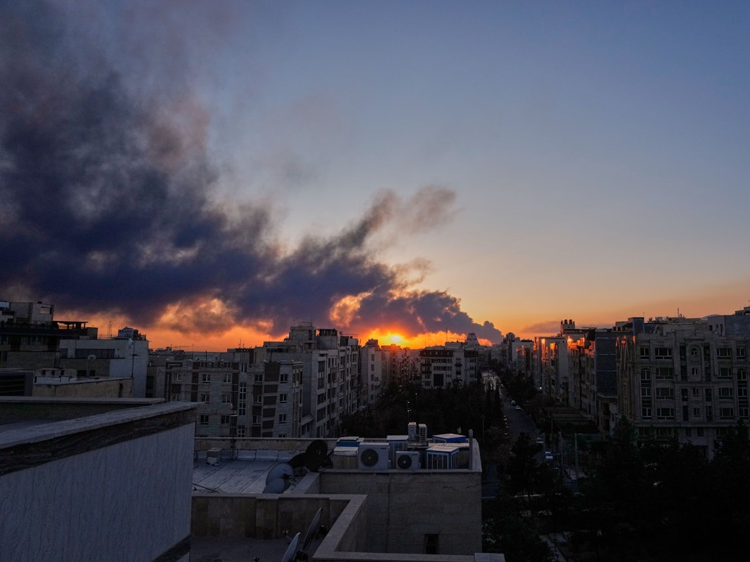 Die Sonne geht hinter einer Rauchwolke unter, die nach einem amerikanisch-israelischen Militärschlag aufsteigt.