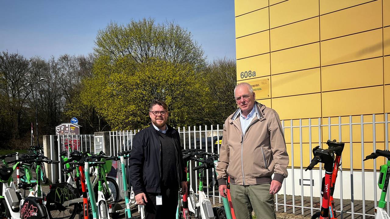 Friedrich Jeschke (li., Volt) und Klaus Reinartz (FDP) inmitten der wild abgestellten E-Scooter nach FC-Spielen
