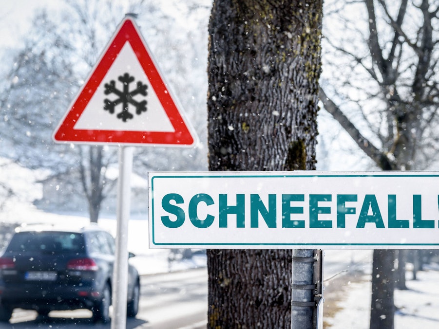 Winterliche Straße mit Warnschildern und Schneeflocken