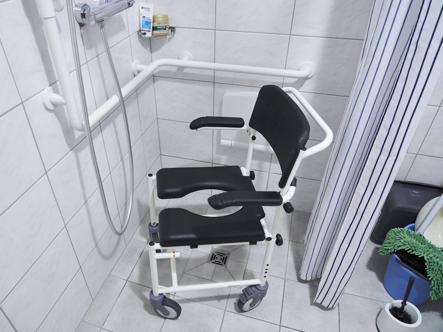 Duschstuhl in gefliestem Badezimmer