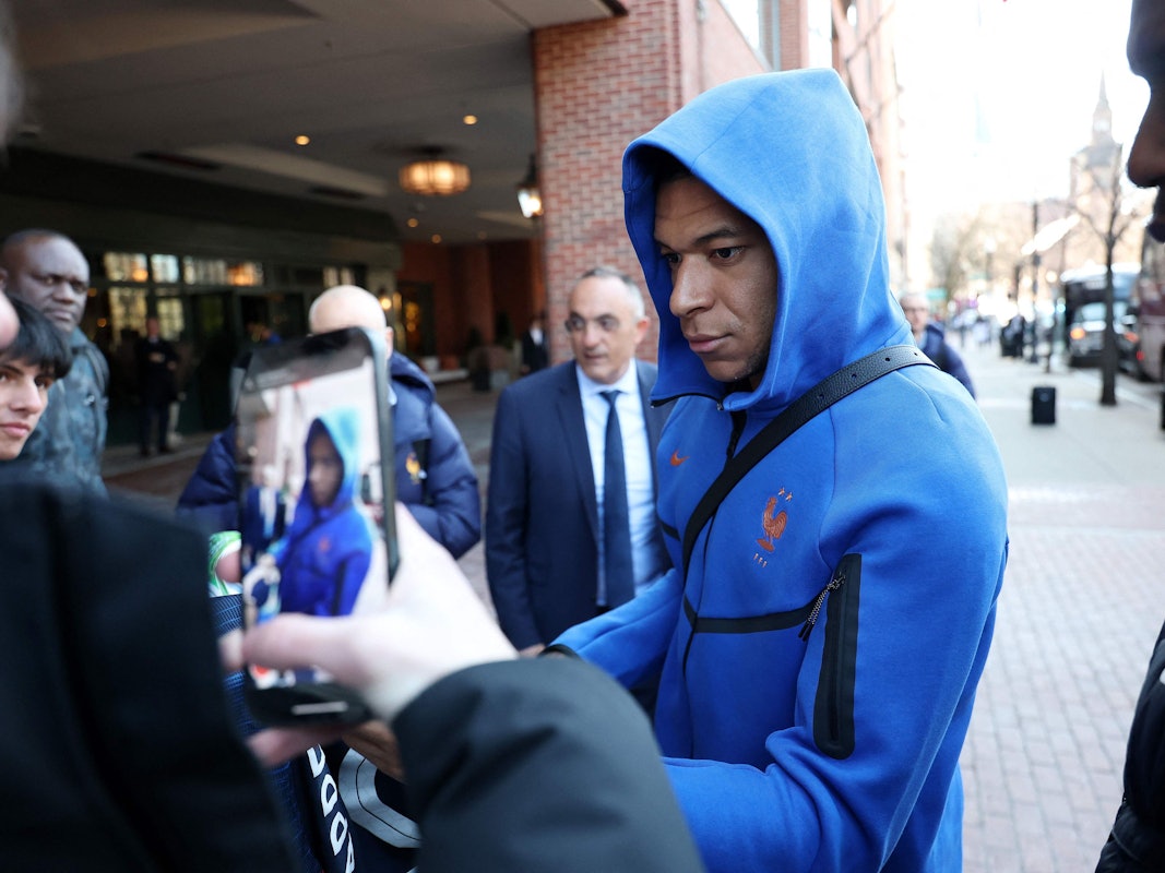 Kylian Mbappé schreibt Autogramme.