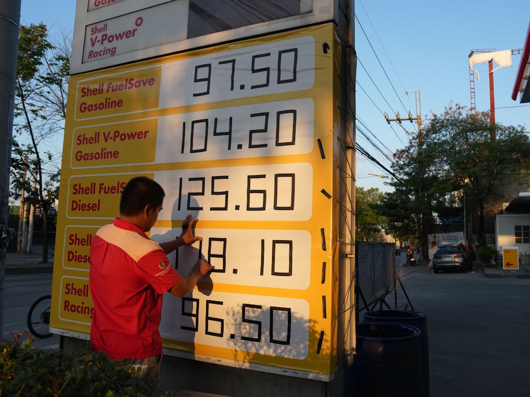 Ein Arbeiter benutzt schwarzes Klebeband, um die Preise auf seinem Schild an einer Tankstelle anzupassen, da die Ölpreise weiter steigen.