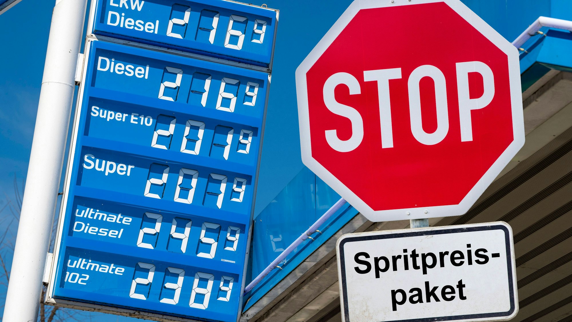 Anzeigetafel mit Spritpreisen und Stopschild „Spritpreispaket“