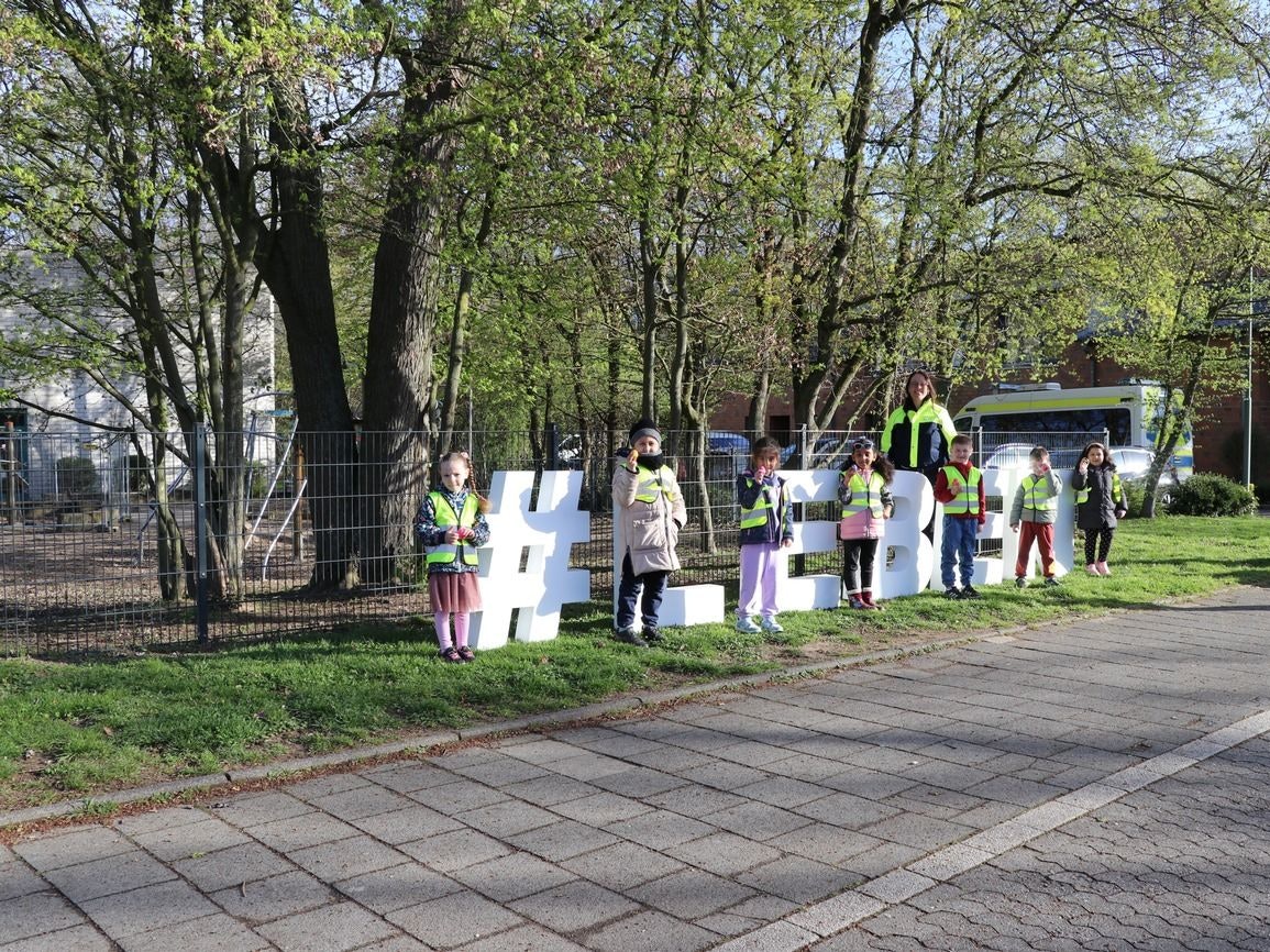 Polizistin und Kind mit Osterei in der Hand.