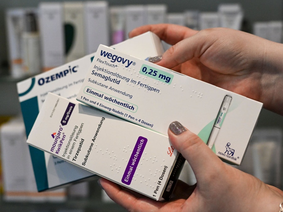 Eine Frau hält Abnehmspritzen verschiedener Marken in den Händen