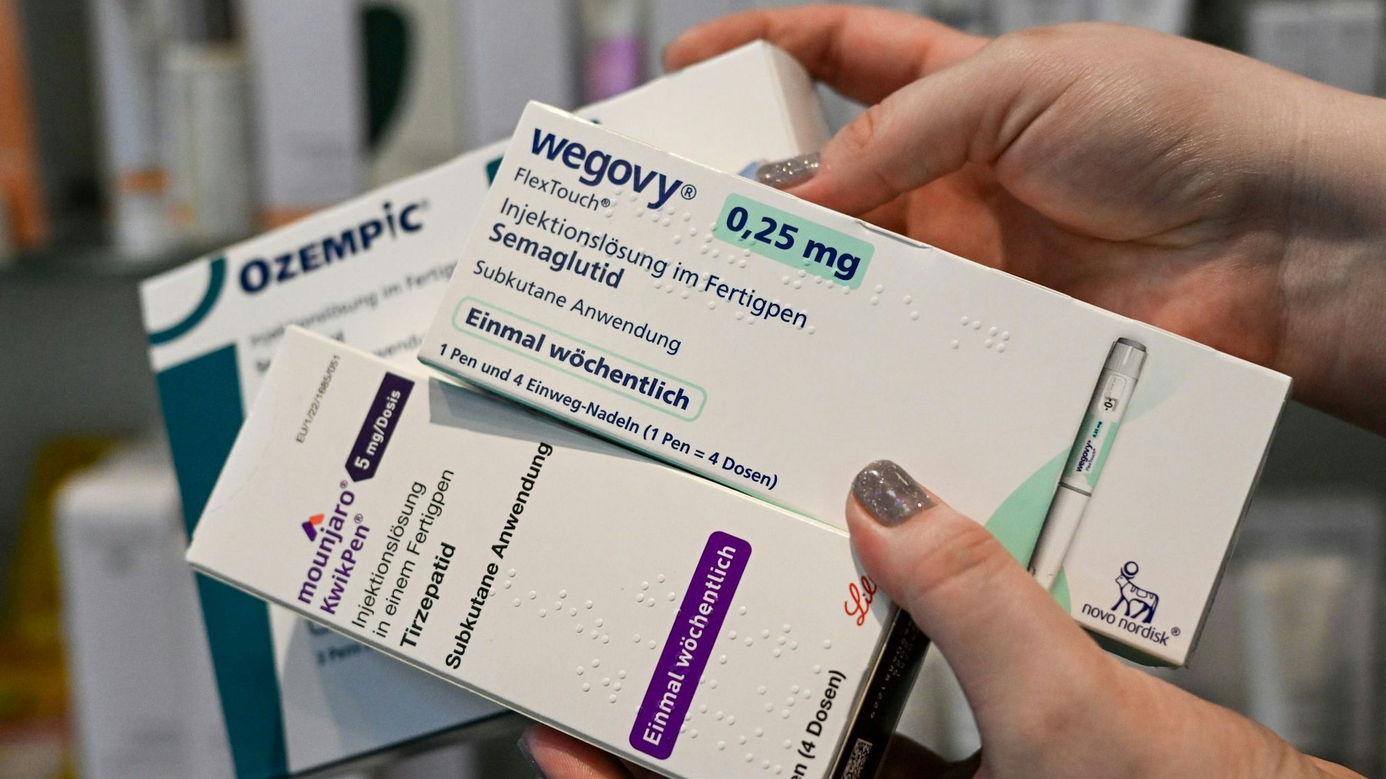 Eine Frau hält Abnehmspritzen verschiedener Marken in den Händen