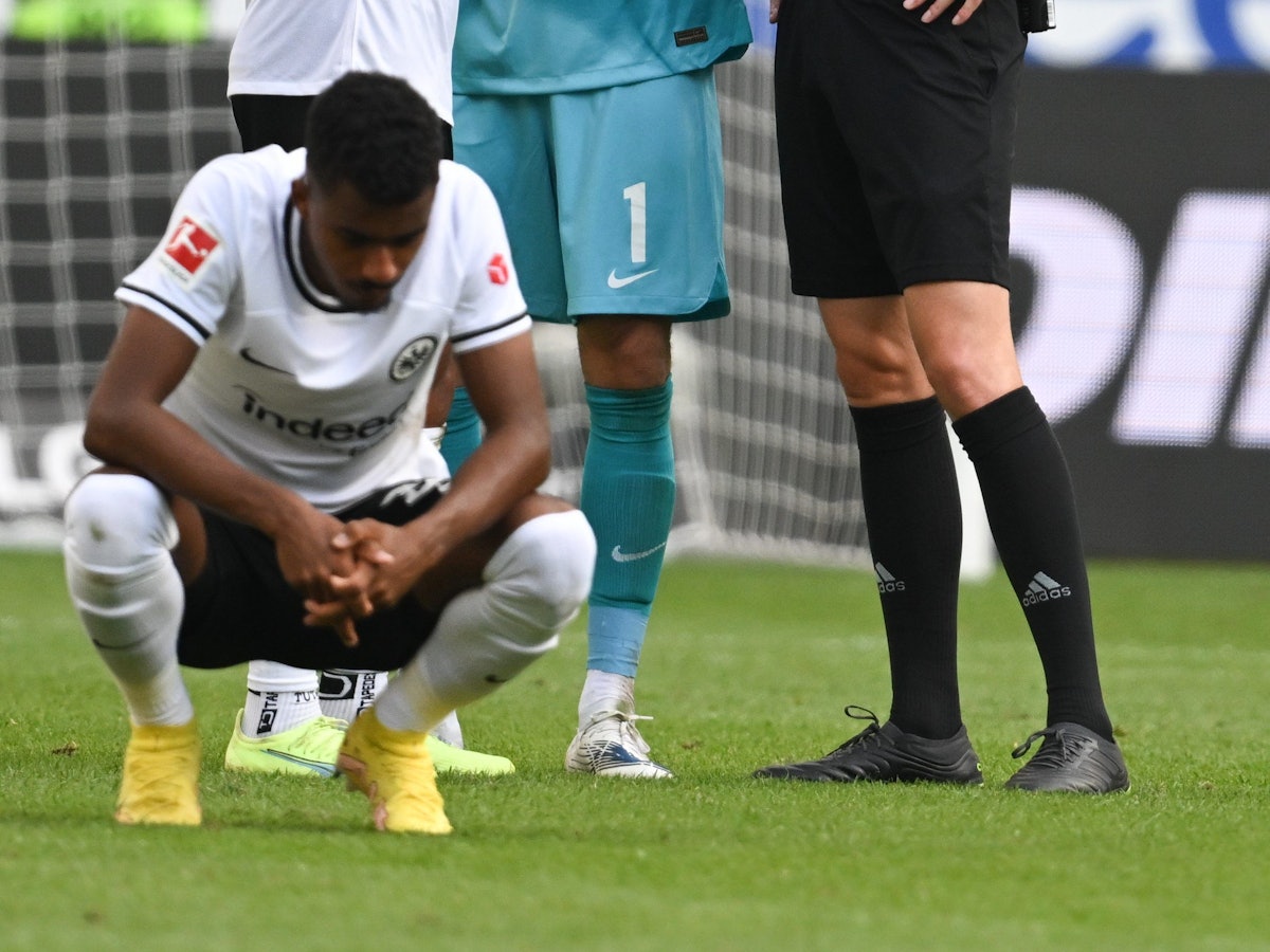 Ansgar Knauff von Eintracht Frankfurt hockt auf dem Fußballplatz während einer Bundesliga-Partie.