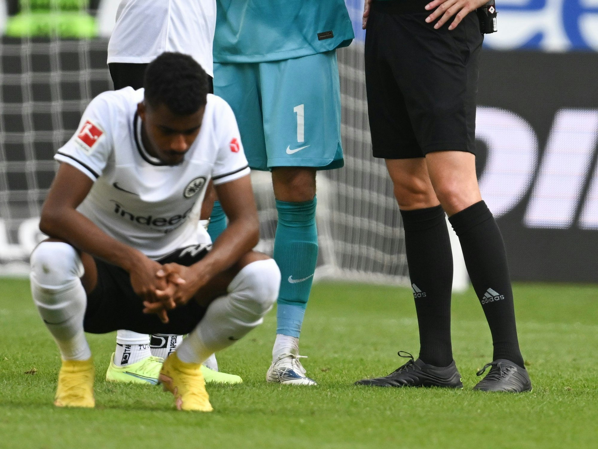 Ansgar Knauff von Eintracht Frankfurt hockt auf dem Fußballplatz während einer Bundesliga-Partie.