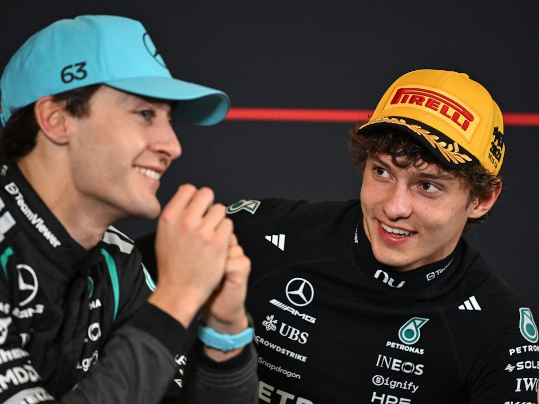 Kimi Antonelli schaut George Russell in einer Pressekonferenz an.