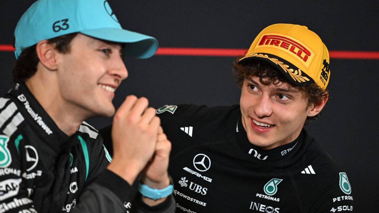 Kimi Antonelli schaut George Russell in einer Pressekonferenz an.