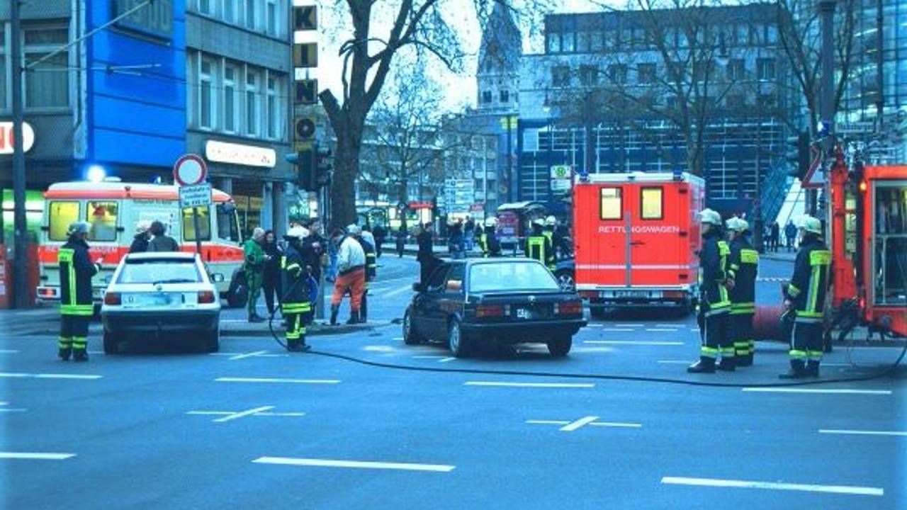 Zwei verunglückte Autos stehen auf einer Straße, um sie herum Einsatzkräfte sowie Fahrzeuge von Rettungsdienst und Feuerwehr.
