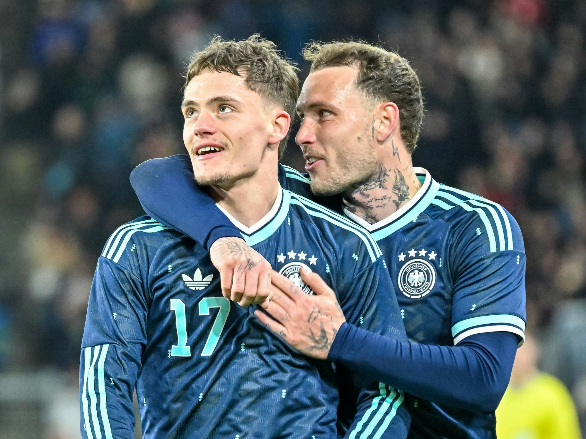 Florian Wirtz (l.) wird auf dem Platz von David Raum umarmt.