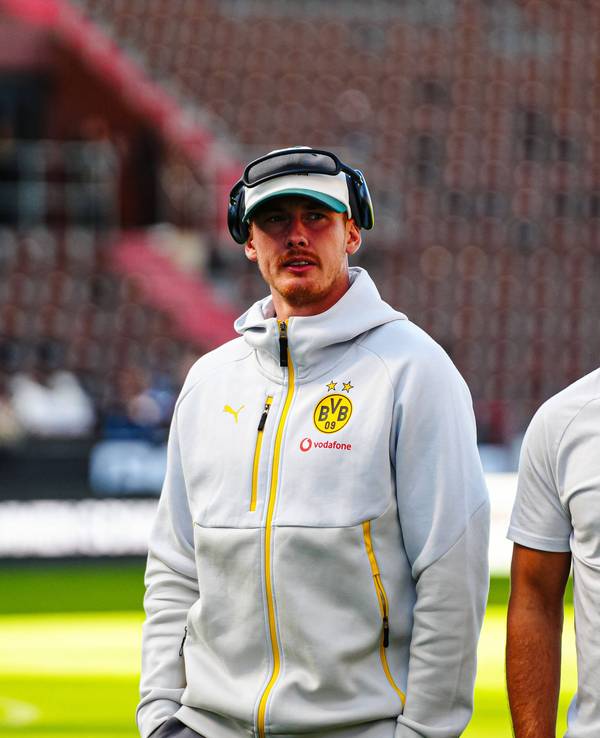 Julian Brandt und Salih Özcan (r.) gehen vor dem Spiel über den Platz.