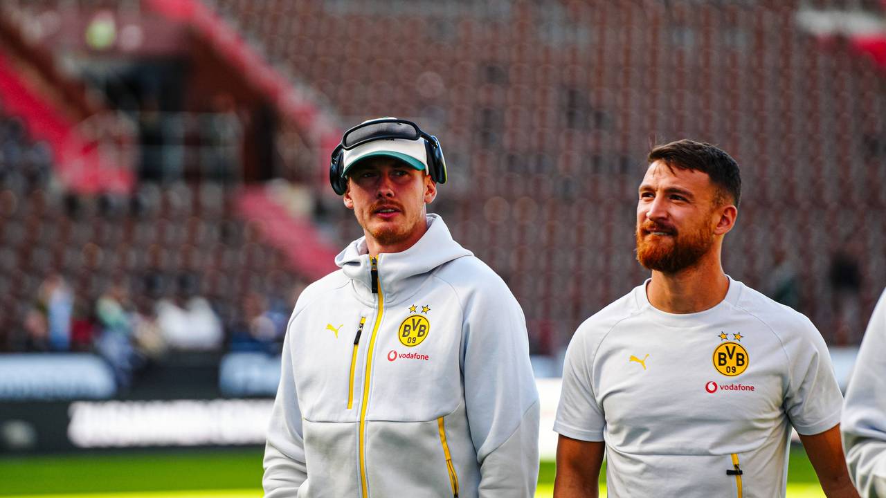 Julian Brandt und Salih Özcan (r.) gehen vor dem Spiel über den Platz.