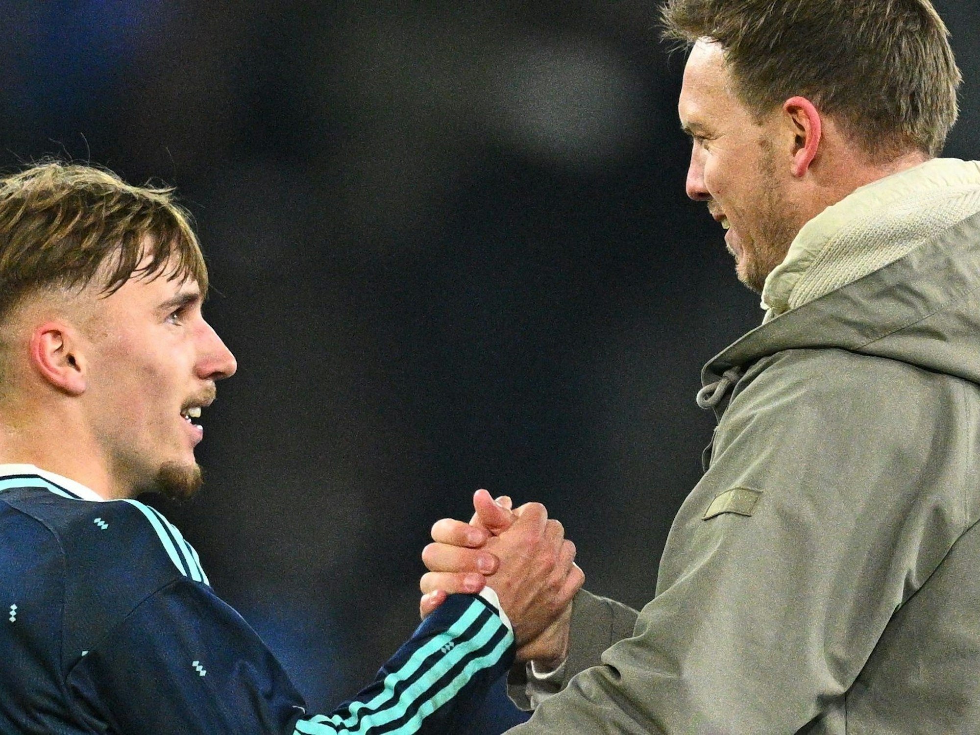 Bundestrainer Julian Nagelsmann klatscht mit Lennart Karl nach dem Abpfiff ab.