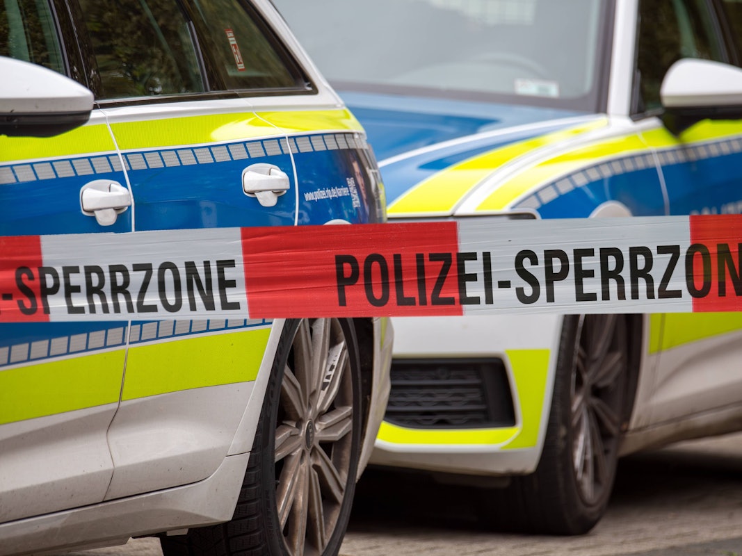 Polizei-Absperrband vor Einsatzfahrzeugen