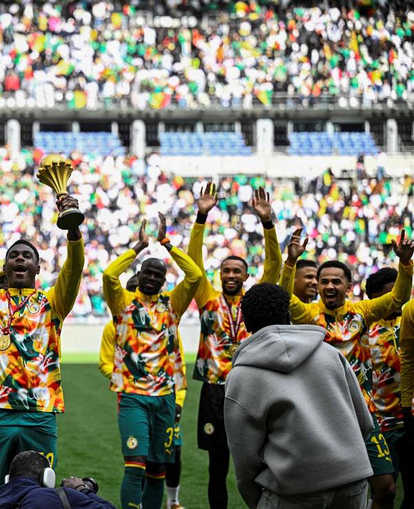 Die Spieler aus dem Senegal tragen den Pokal für den Sieger des Afrika Cups auf einer Art Ehrenrunde im Stade de France.