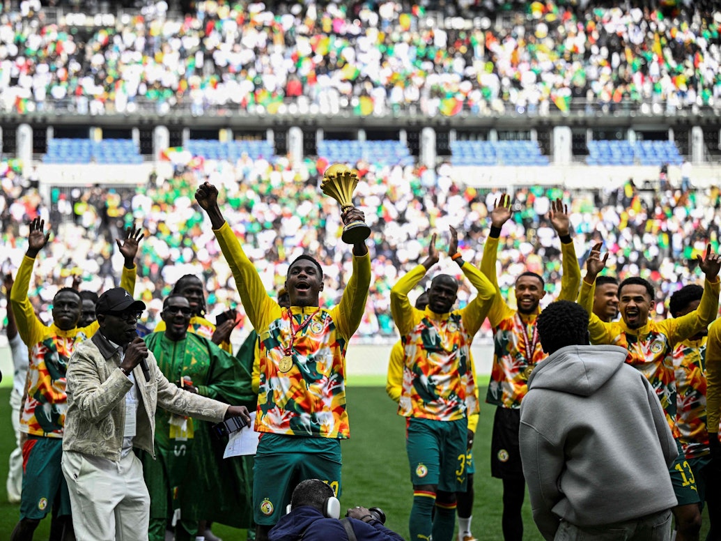 Die Spieler aus dem Senegal tragen den Pokal für den Sieger des Afrika Cups auf einer Art Ehrenrunde im Stade de France.