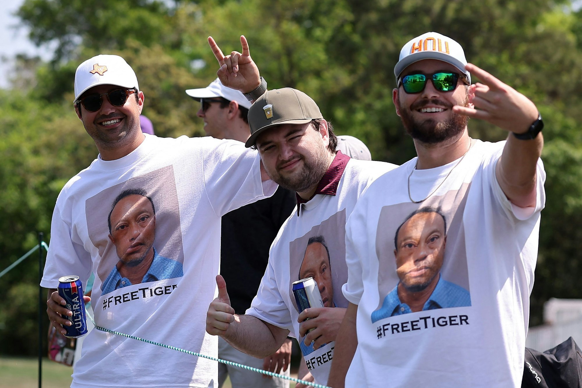 Fans posieren am 28. März kurz nach dem jüngsten Vorfall mit einem Polizeifoto von Tiger Woods auf weißen T-Shirts zur Unterstützung des Sportlers während der dritten Runde der Texas Children's Houston Open auf dem Memorial Park Golf.