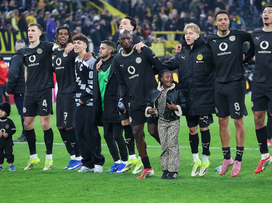 Spieler von Borussia Dortmund feiern mit ihren Kindern vor de Fankurve.
