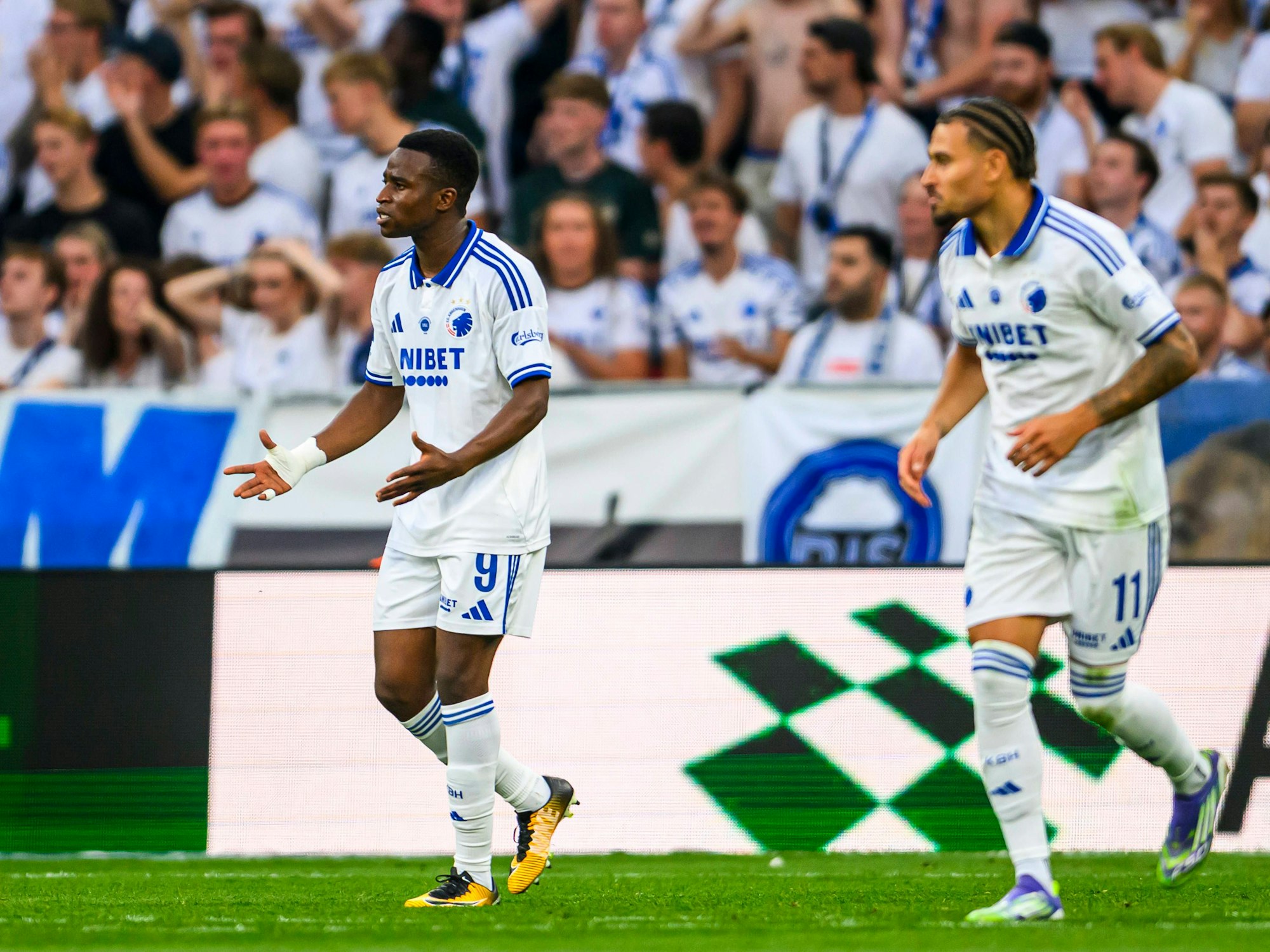 Youssoufa Moukoko (l.) hebt kritisch die Arme.