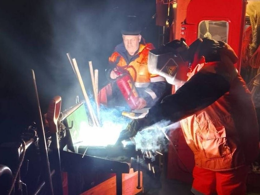 Zwei Männer schweißen und halten Feuerlöscher